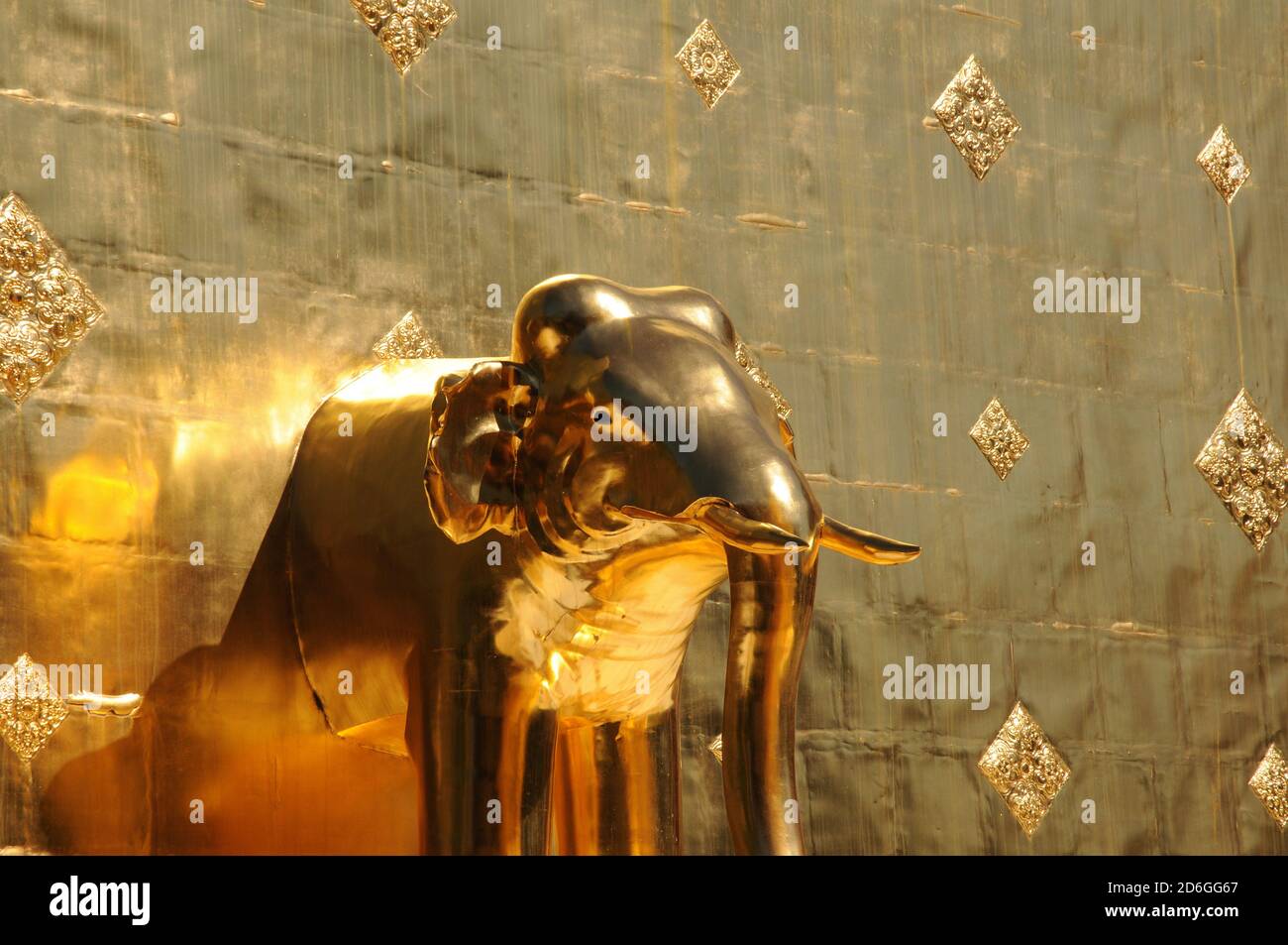 Elephant statue at the base of the golden chedi at Wat Phra Singh, Chiang Mai, Thailand Stock Photo
