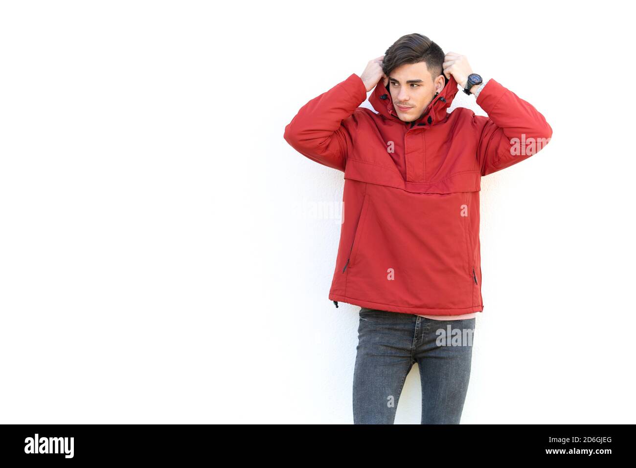 young man in red coat over white wall Stock Photo