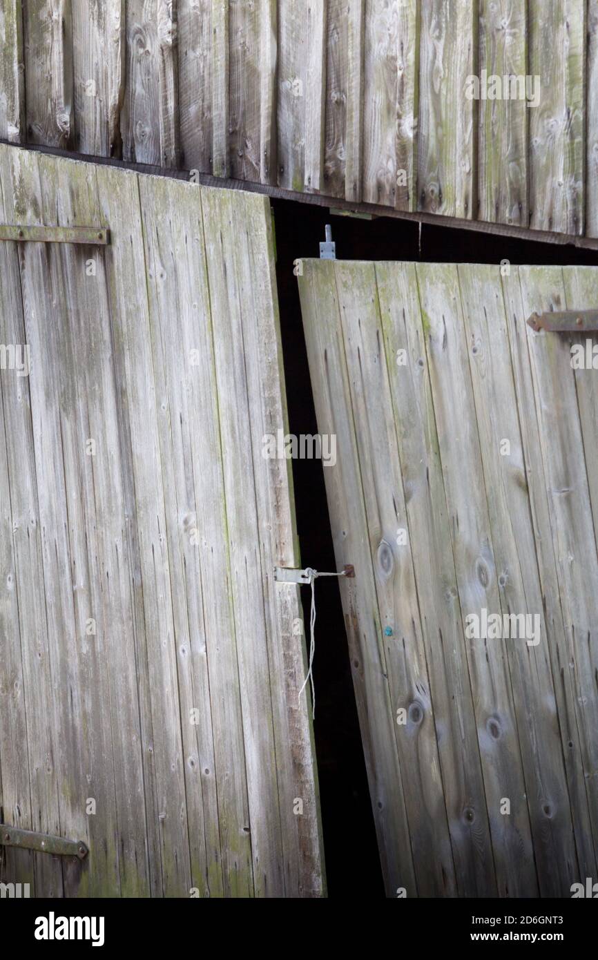 Wooden doors on a wonky old timber barn Stock Photo
