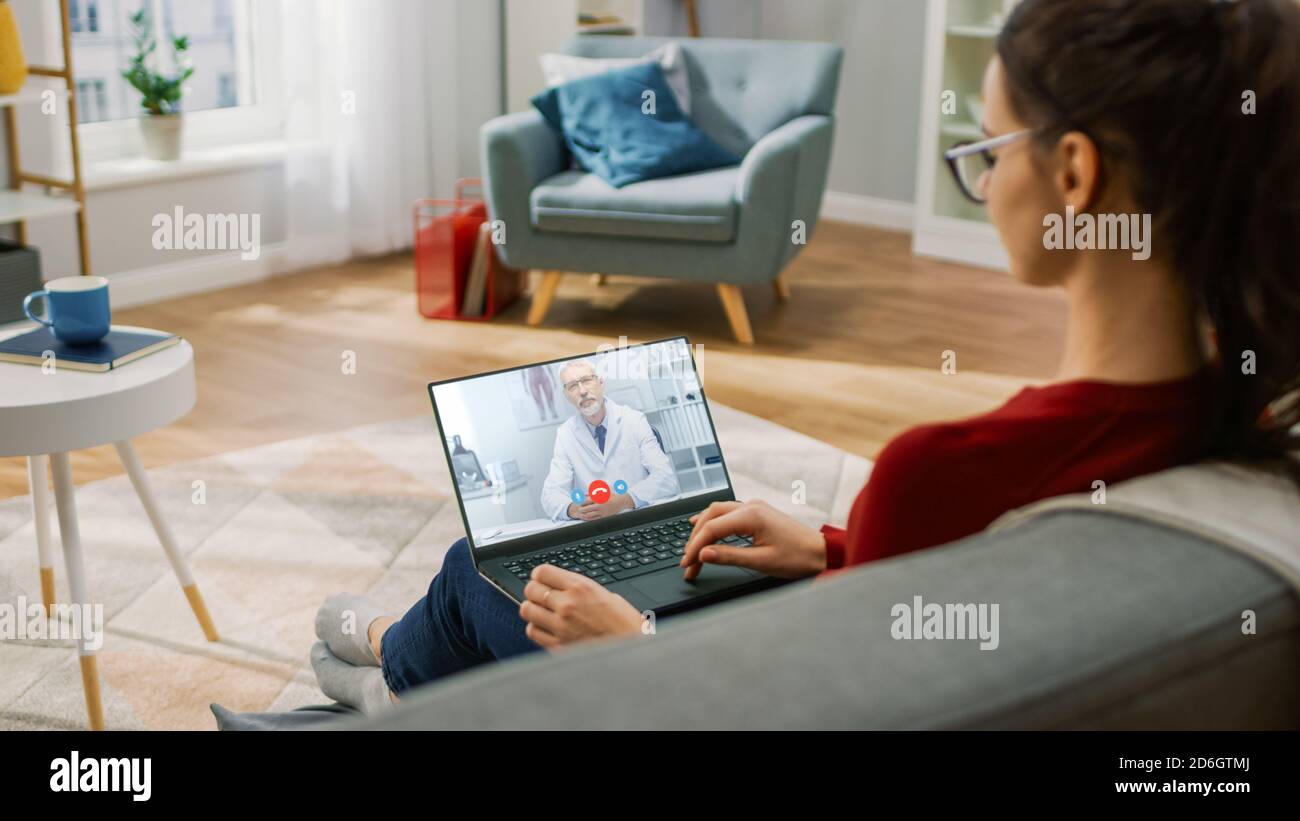 Young Girl Sick at Home Using Laptop Computer to Talk to Her Doctor via ...