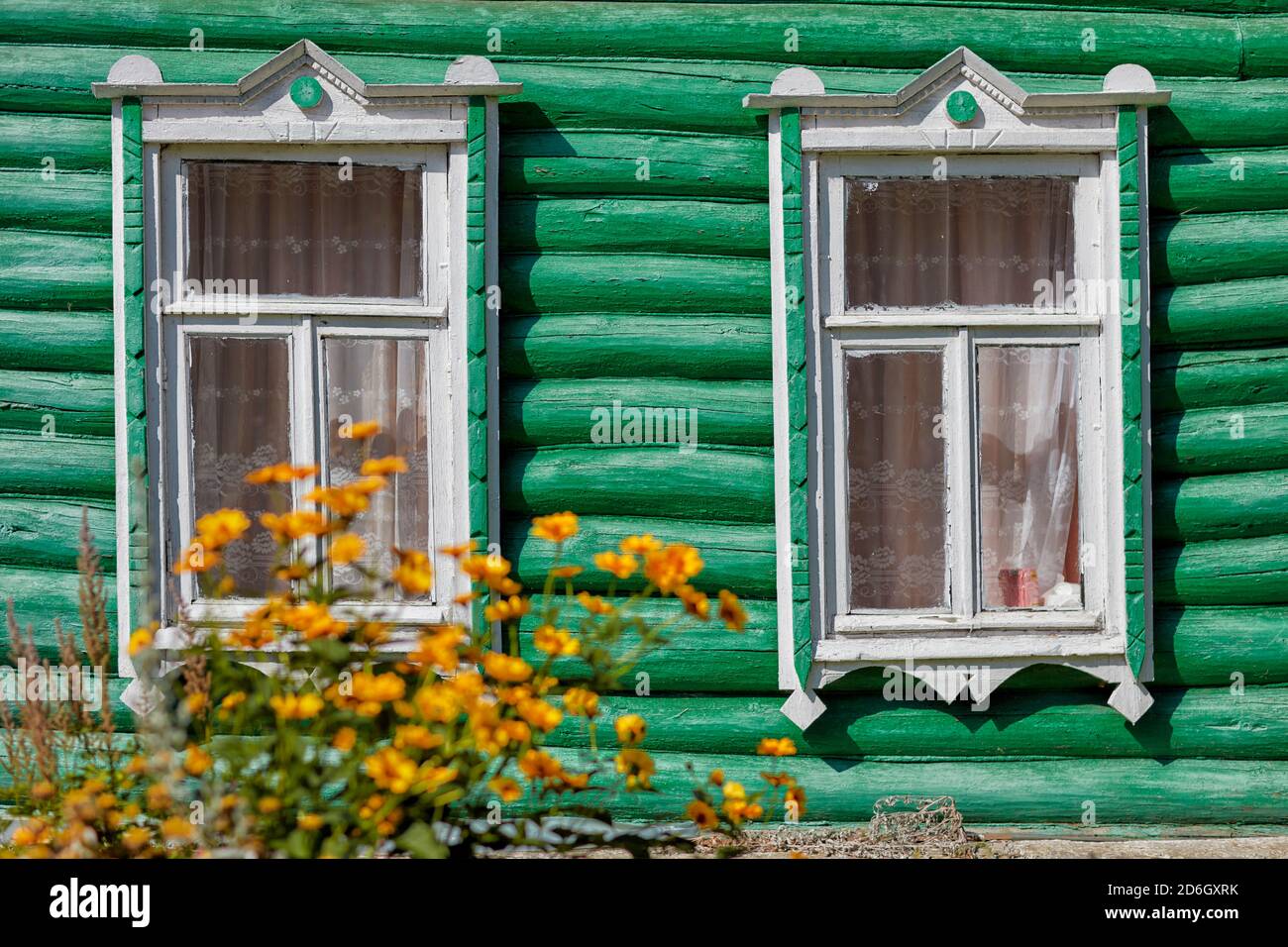 Two windows in the green wall of an old log house. Kaluga Oblast, Russia. Stock Photo
