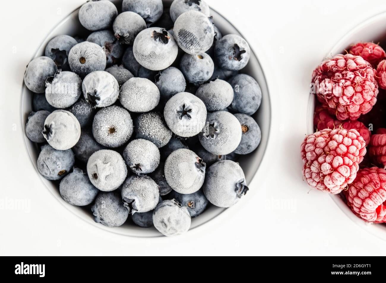 Frozen blueberries and raspberries on a white background. Top view