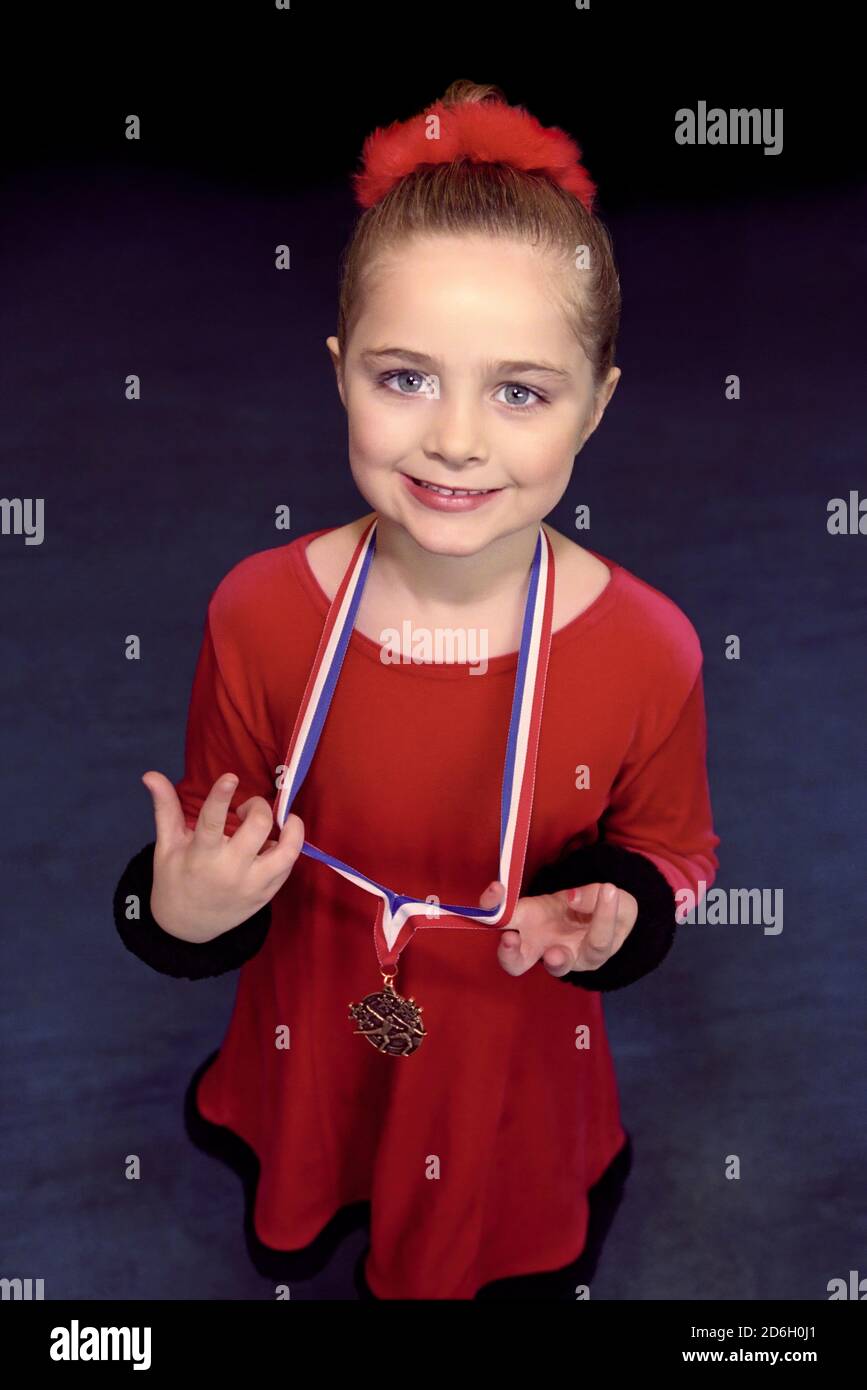Young child holding award after performance Stock Photo