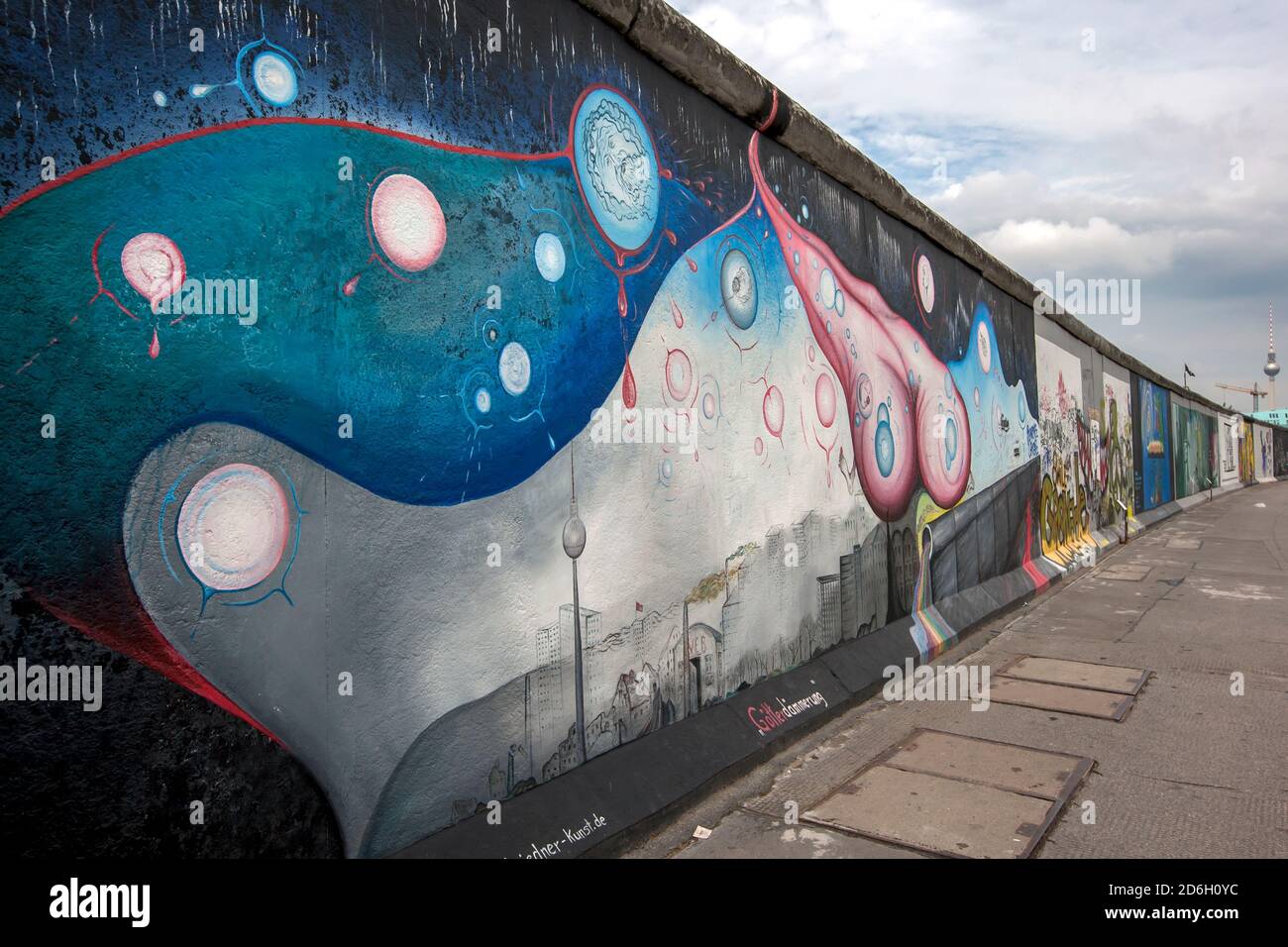 Colourful murals cover a section of the former infamous Berlin Wall in Germany. The Berlin Wall was a barrier that divided East and West Berlin. Stock Photo