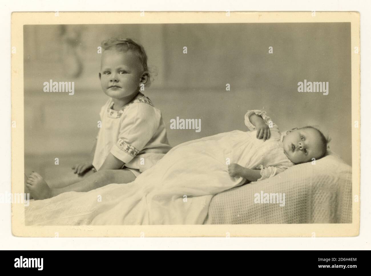Studio portrait postcard of baby in christening gown and toddler, circa 1940's, U.K Stock Photo