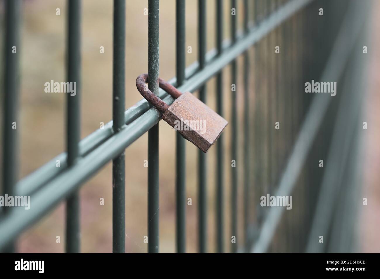 a locked padlock hangs on a fence Stock Photo
