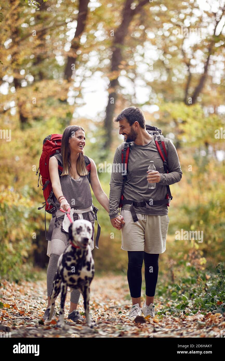 A young couple and their dog at hiking through the woods Stock Photo ...