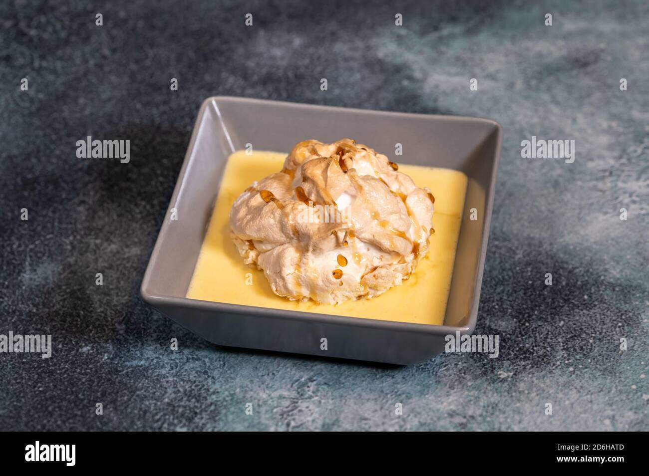 Floating island dessert made of meringue floating on vanilla custard
