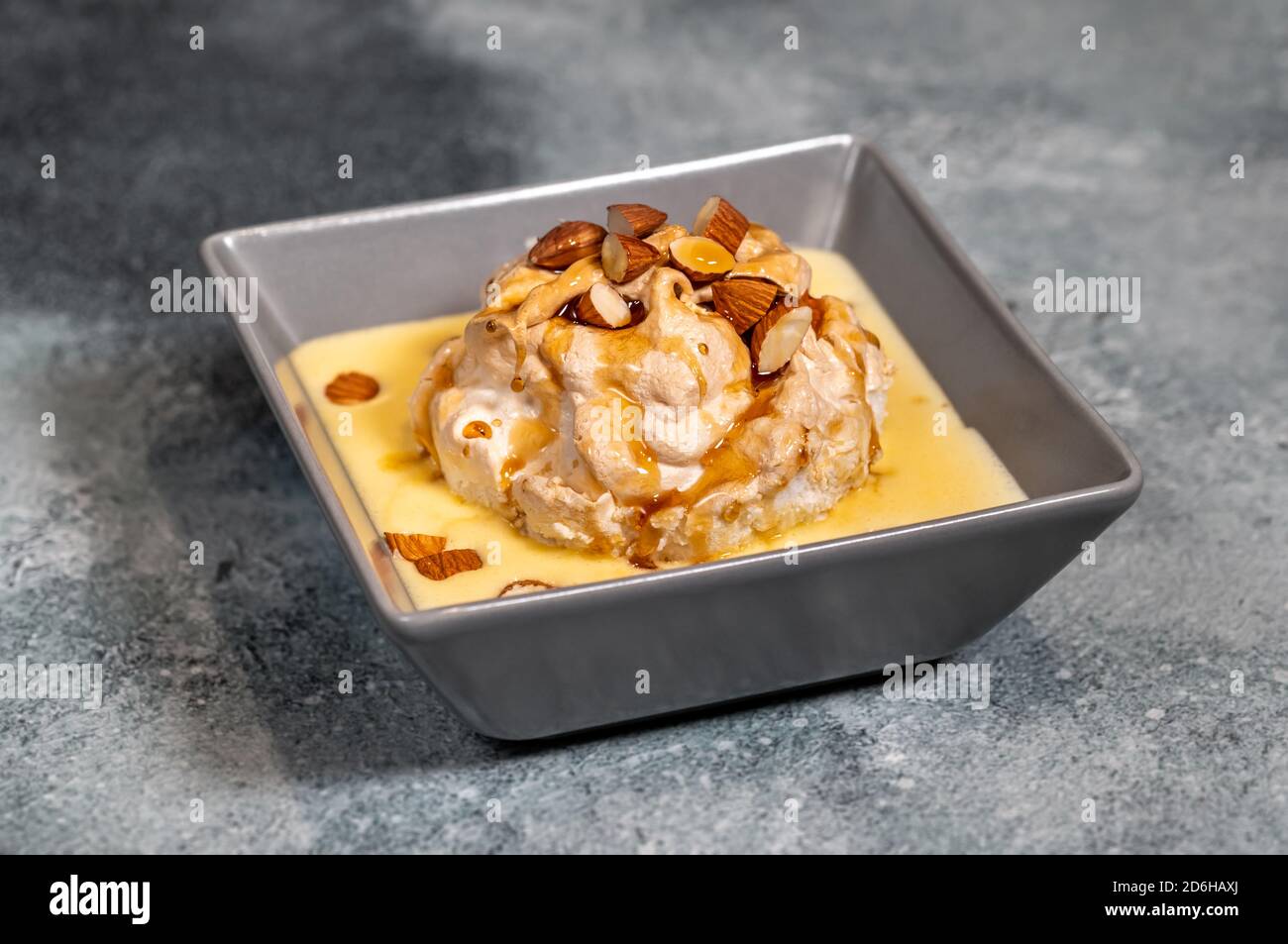 Floating island dessert made of meringue floating on vanilla custard