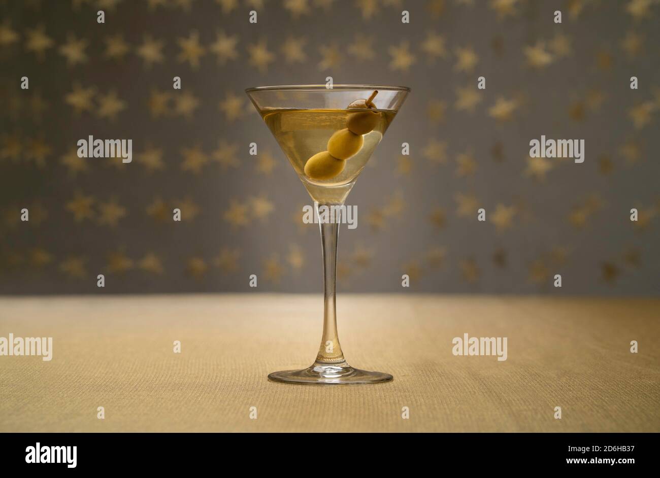 vodka martini with olives inside on golden fabric with starry background Stock Photo