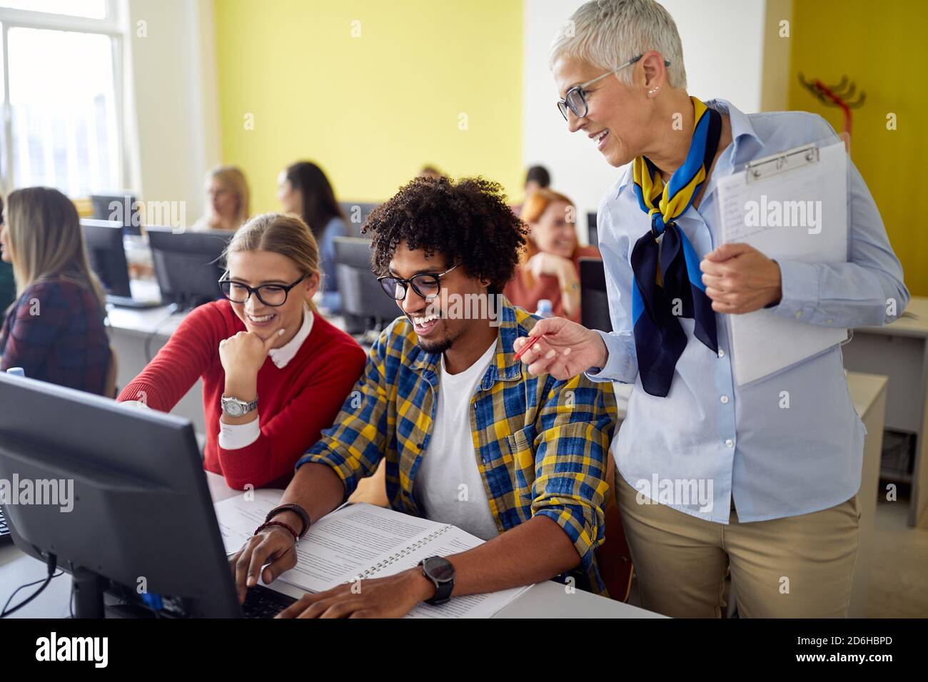 A female professor following work of students at the informatics ...