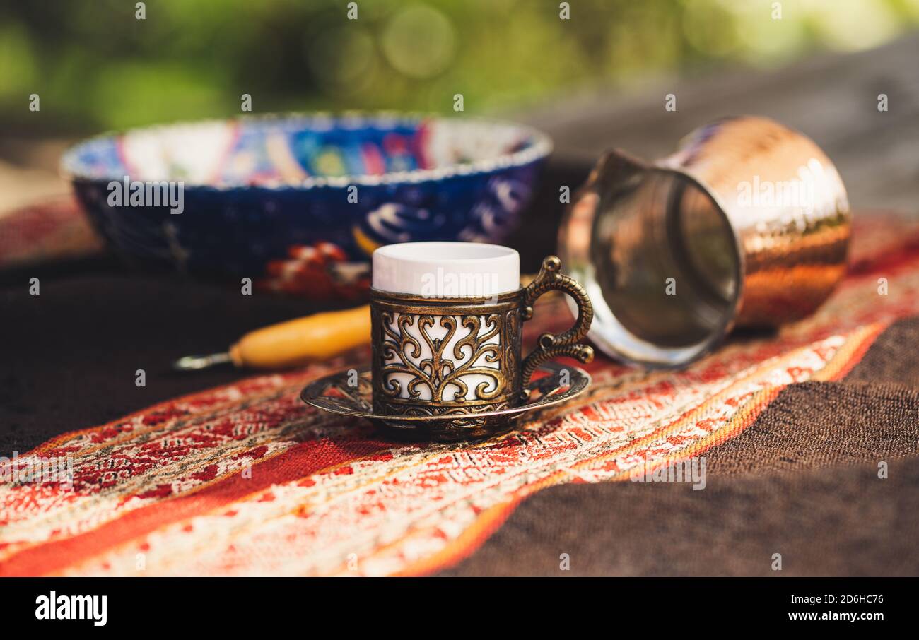 Turkish coffee cups with a glass of water on a wooden table with a white cloth photographed from above Stock Photo