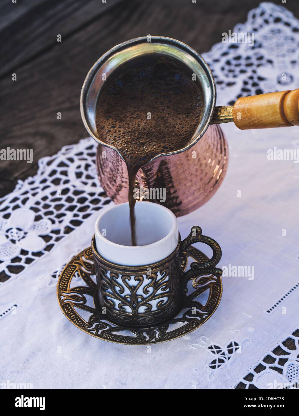 Turkish coffee cups with a glass of water on a wooden table with a white cloth photographed from above Stock Photo