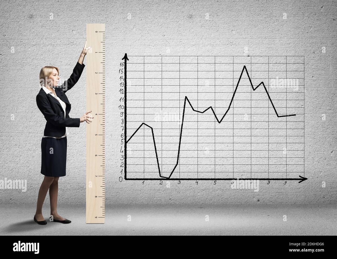 Woman in business suit holding big ruler Stock Photo - Alamy