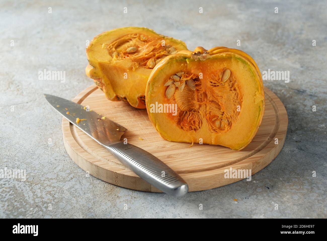 Halved Kamo-Kamo pumpkin or squash with seeds on a kitchen board, seasonal vegetable for a delicious autumn dish, copy space, selected focus, narrow d Stock Photo