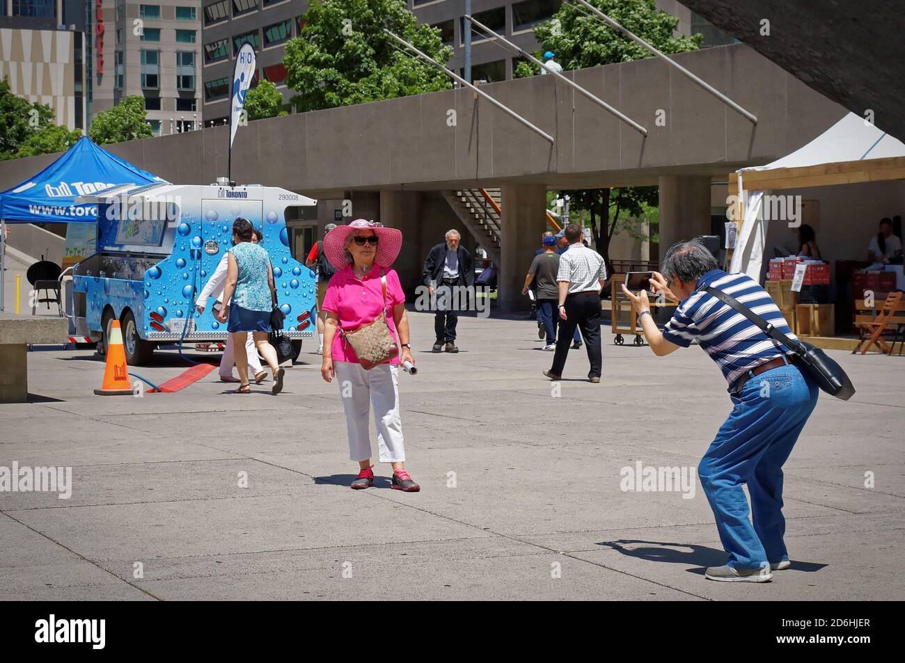 TORONTO, CANADA - 06 27 2016: A tourists couple taking a photo in the main square of Toronto Nathan Phillips Square to memorize their stay in major Stock Photo