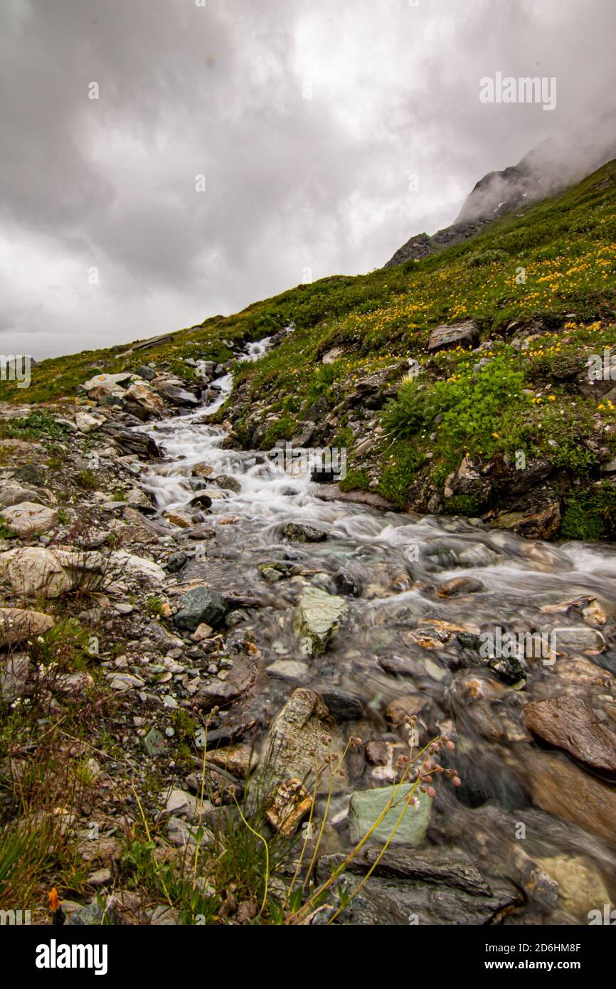 Mountain stream in the Switzerland. net blue water in Swiss Alps Stock Photo