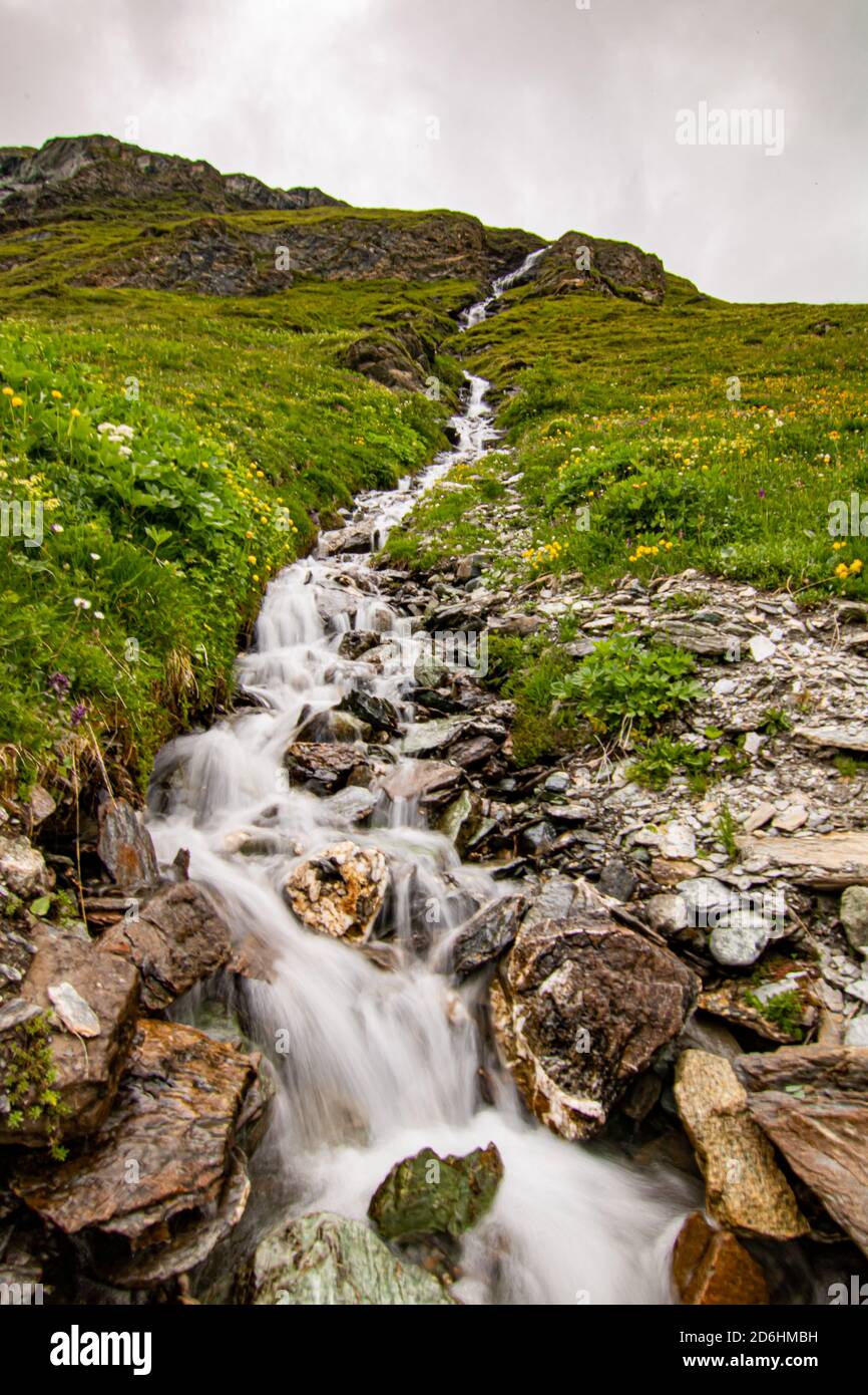 Mountain stream in the Switzerland. net blue water in Swiss Alps Stock