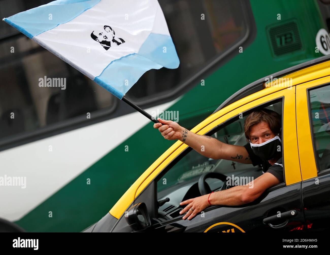 A taxi driver waves an Argentine flag depicting Argentina's late President Juan Domingo Peron and his late wife and first lady Eva Peron during a demonstration in support of Alberto Fernandez's administration on Loyalty Day, in commemoration of the 75th anniversary of the birth of Peronism, in Buenos Aires, Argentina October 17, 2020. REUTERS/Agustin Marcarian Stock Photo