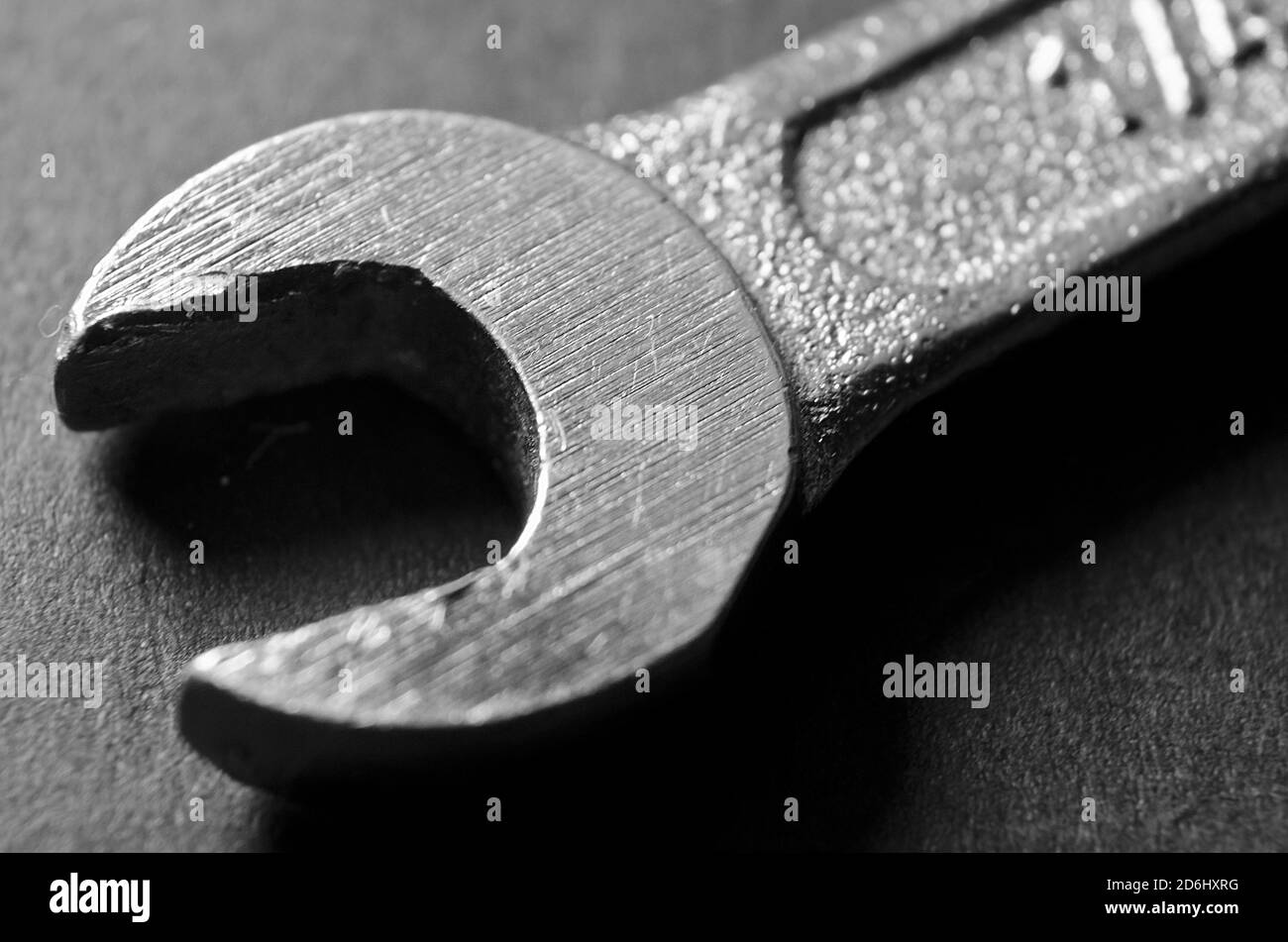 Macro grayscale shot of a metal wrench on a dark surface Stock Photo