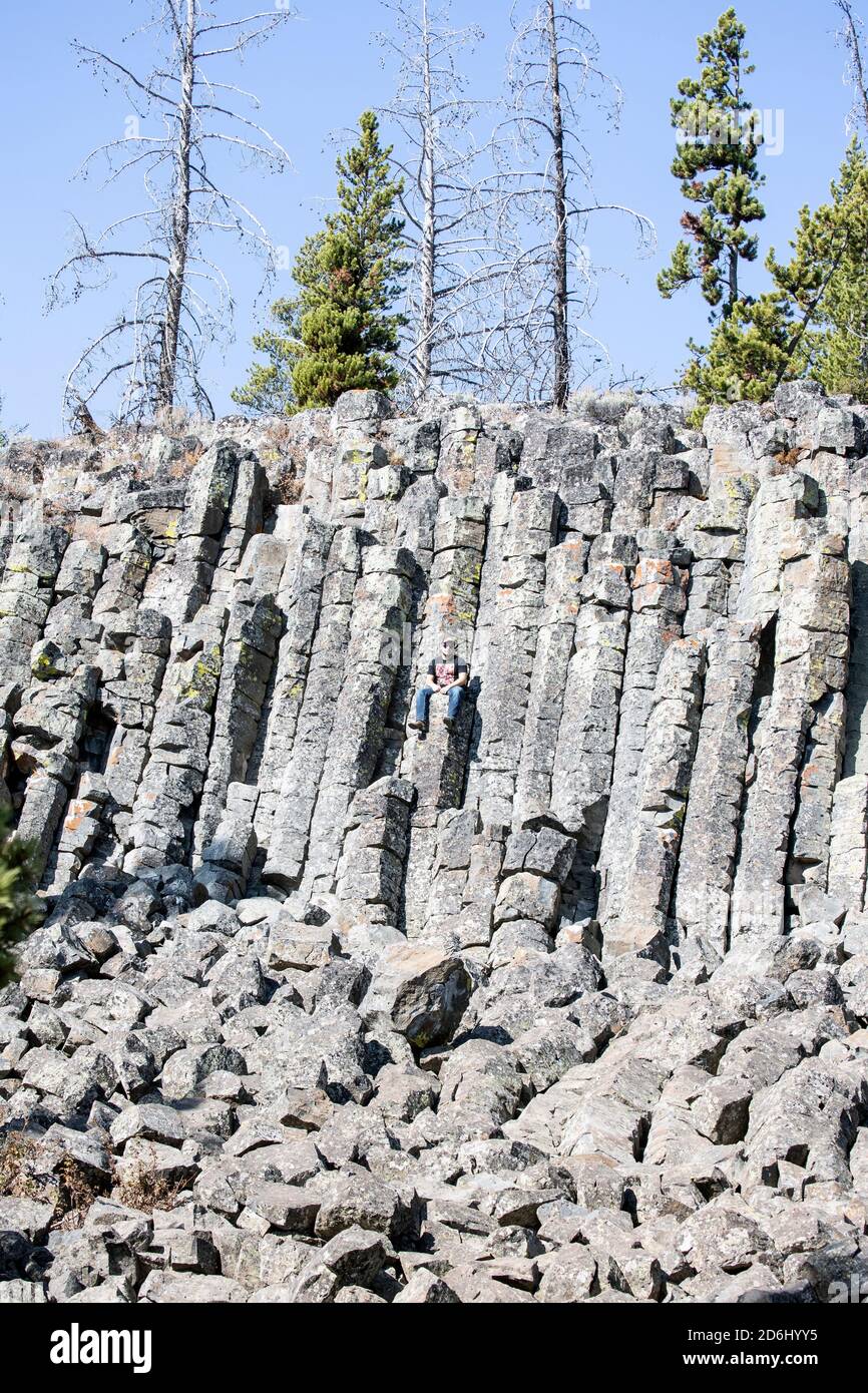 Man Sitting on Basalt Lava Stock Photo