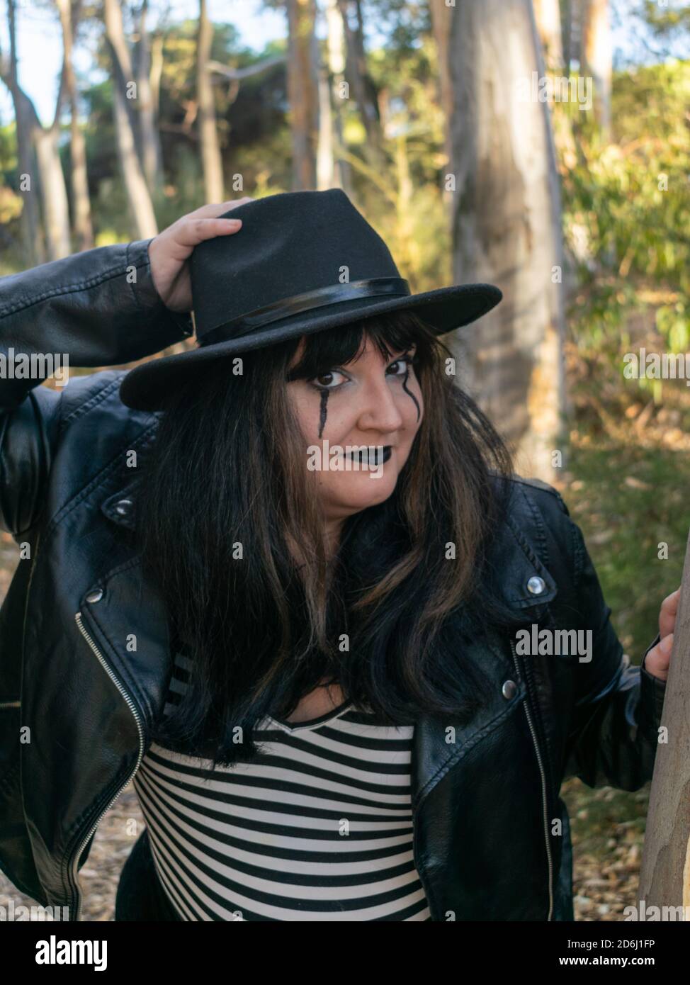 Shallow focus shot of a white fat female posing disguised for the Halloween in a forest Stock Photo