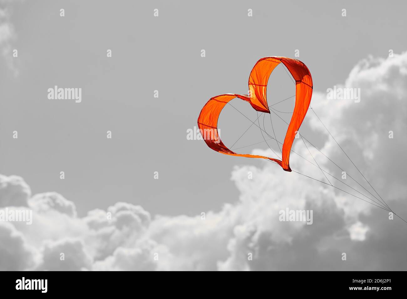 Sunlit heart-shaped dragon, orange heart in front of grey sky, North Rhine-Westphalia, Germany Stock Photo