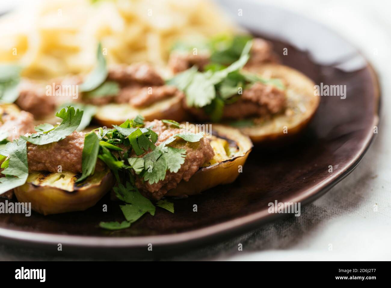 Plate with grilled eggplant slices served with a walnut sauce. Stock Photo
