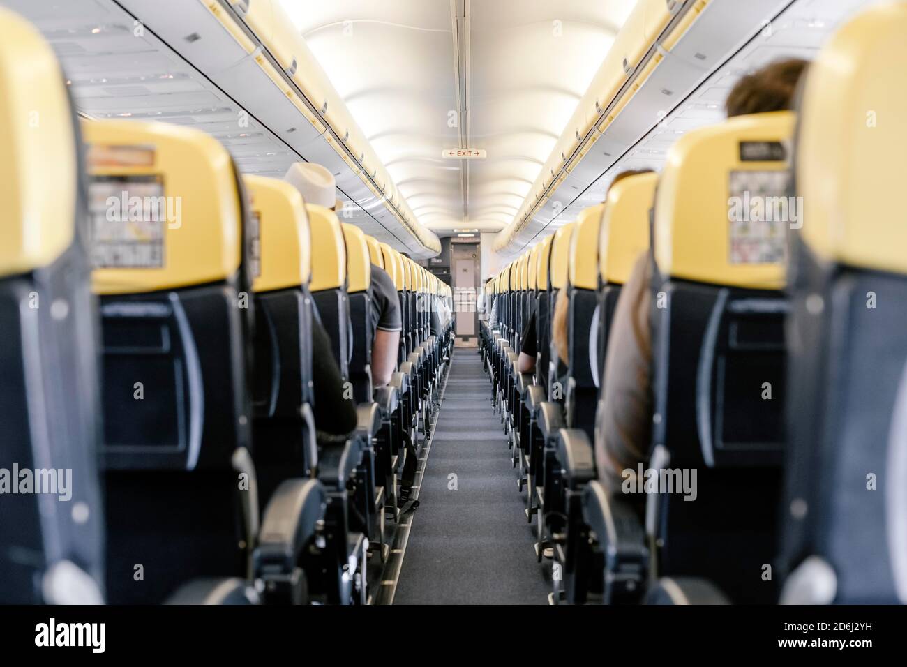 Empty corridor in the airplane with all passengers sitting down Stock Photo