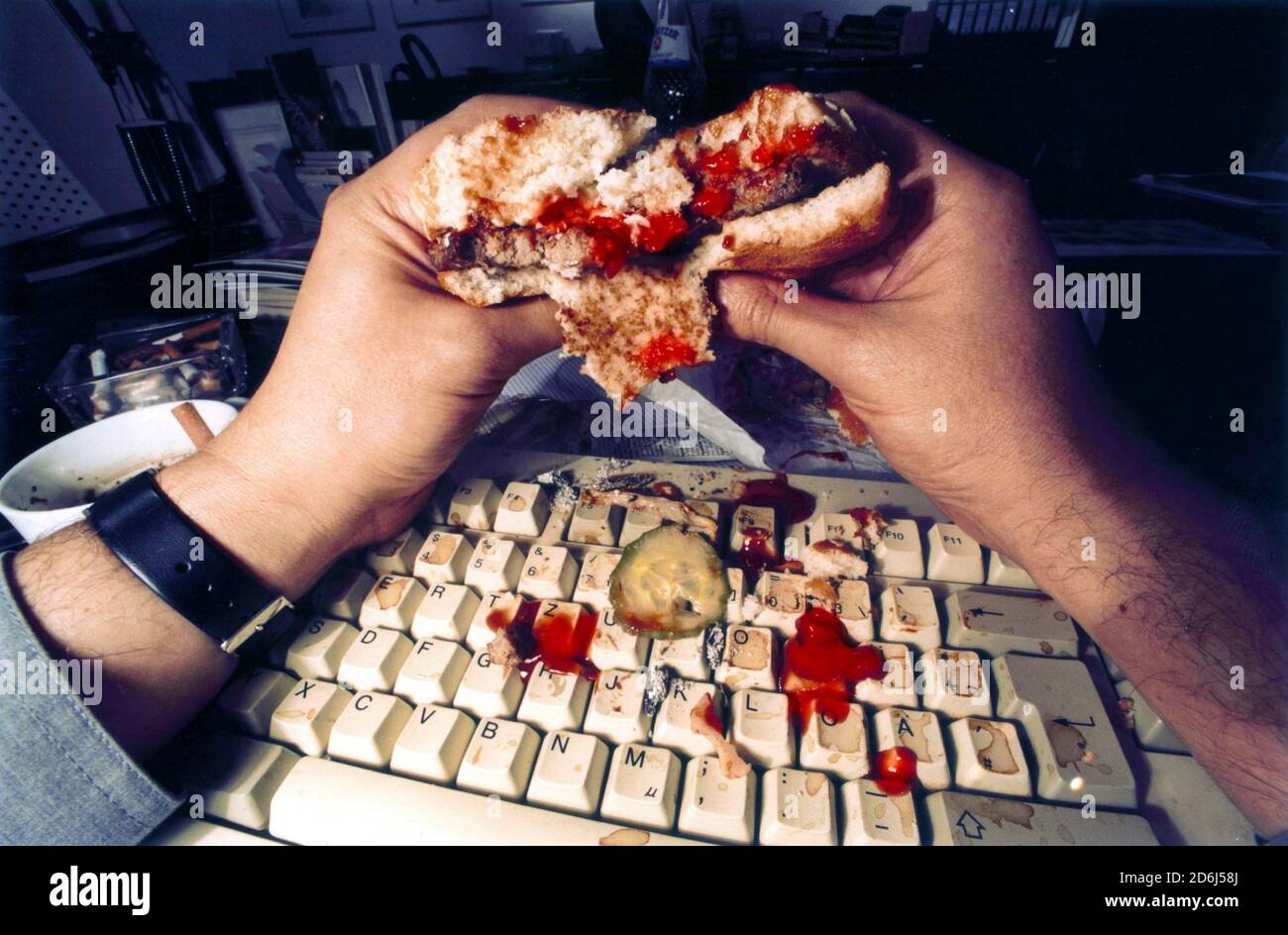 Nerd, man is hamburger on computer, keyboard, disgusting, dirt, Berlin, Germany Stock Photo