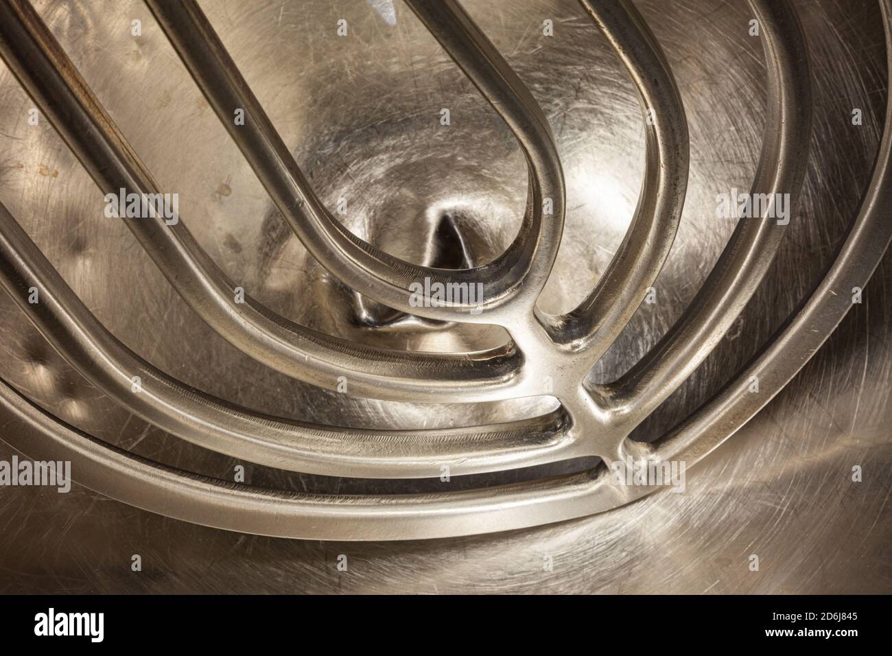 https://c8.alamy.com/comp/2D6J845/abstract-image-of-a-large-aluminum-mixer-paddle-in-a-140-quart-stainless-steel-mixing-bowl-2D6J845.jpg