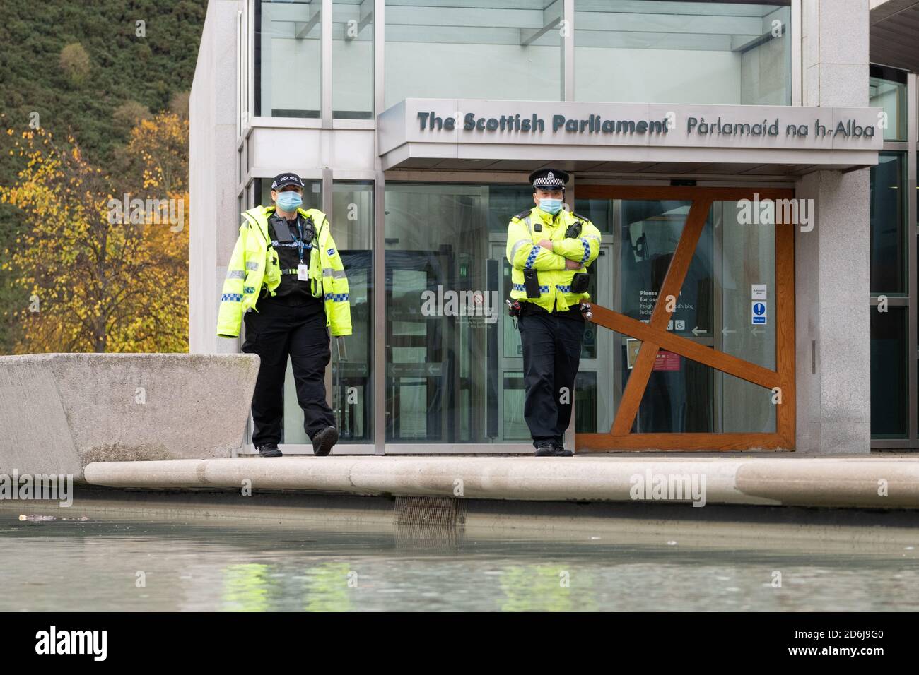 Police officers wearing facemasks outside Scottish Parliament Building during coronavirus pandemic, Edinburgh, Scotland, UK Stock Photo