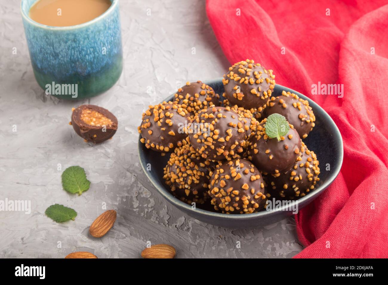 Chocolate caramel ball candies with almonds and a cup of coffee on a