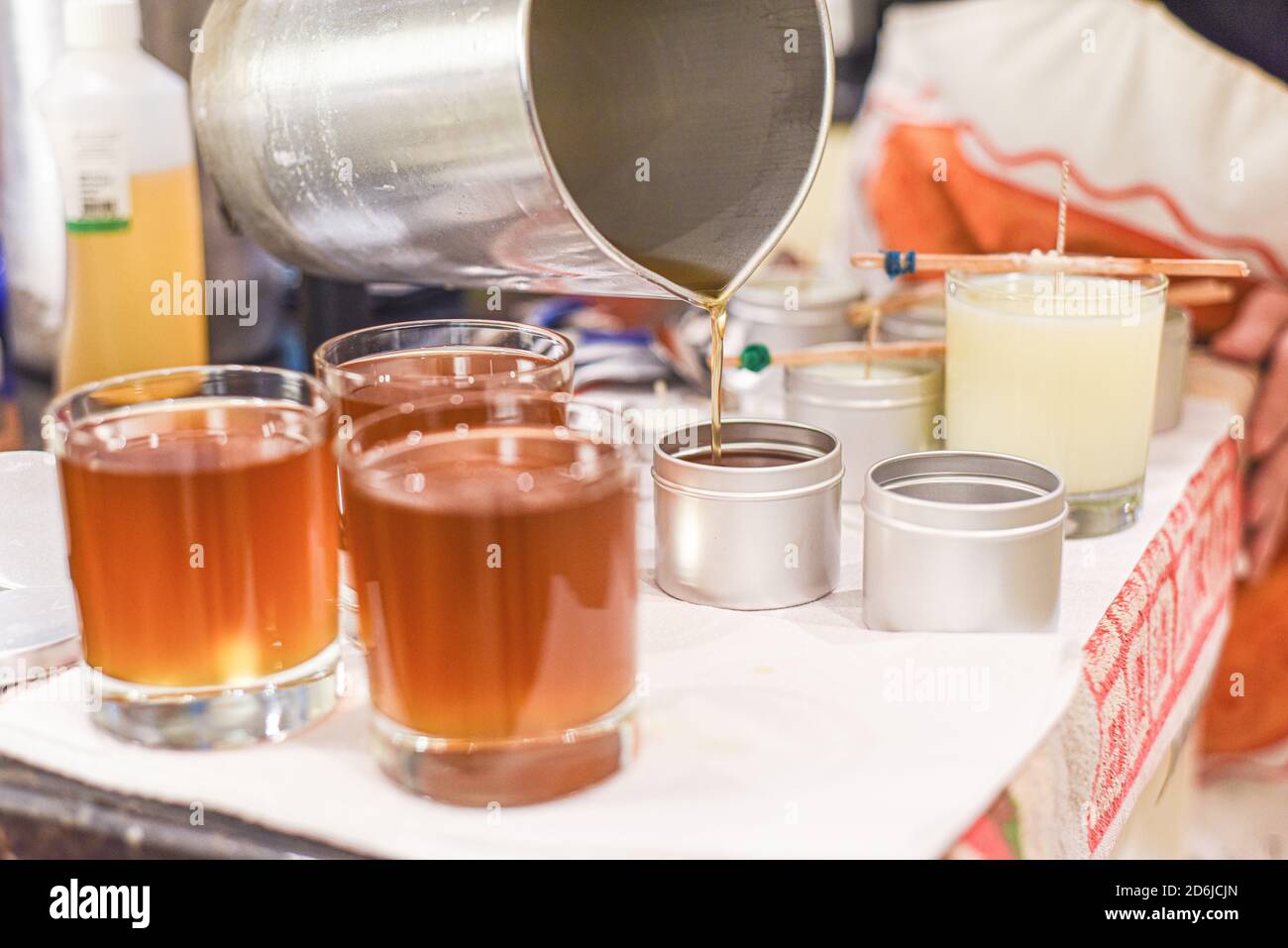 Creative occupation of candle making showing the pouring of liquid wax ...