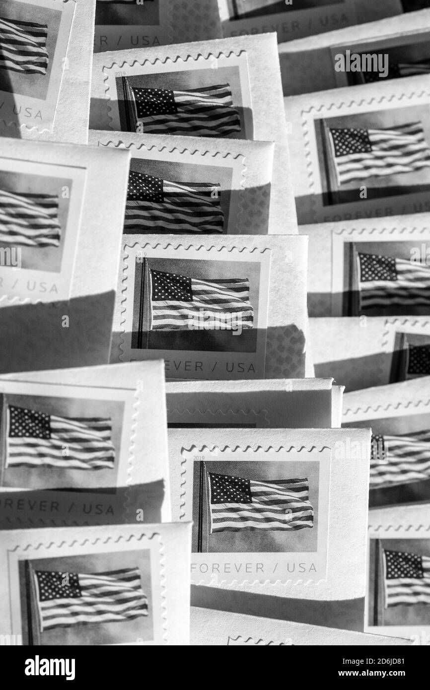 Letters in stamped envelopes, for The Big Send initiative by Vote Forward, are fanned out like a collage, sunlight creating lines of dark shadows Stock Photo