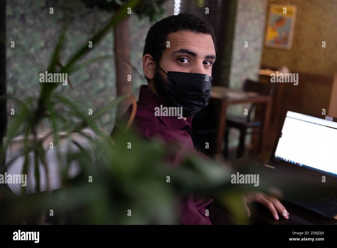 African businessman or developer wearing surgical face mask in the restaurant and typing on laptop - concept on new normal everyday lifestyle and peop Stock Photo