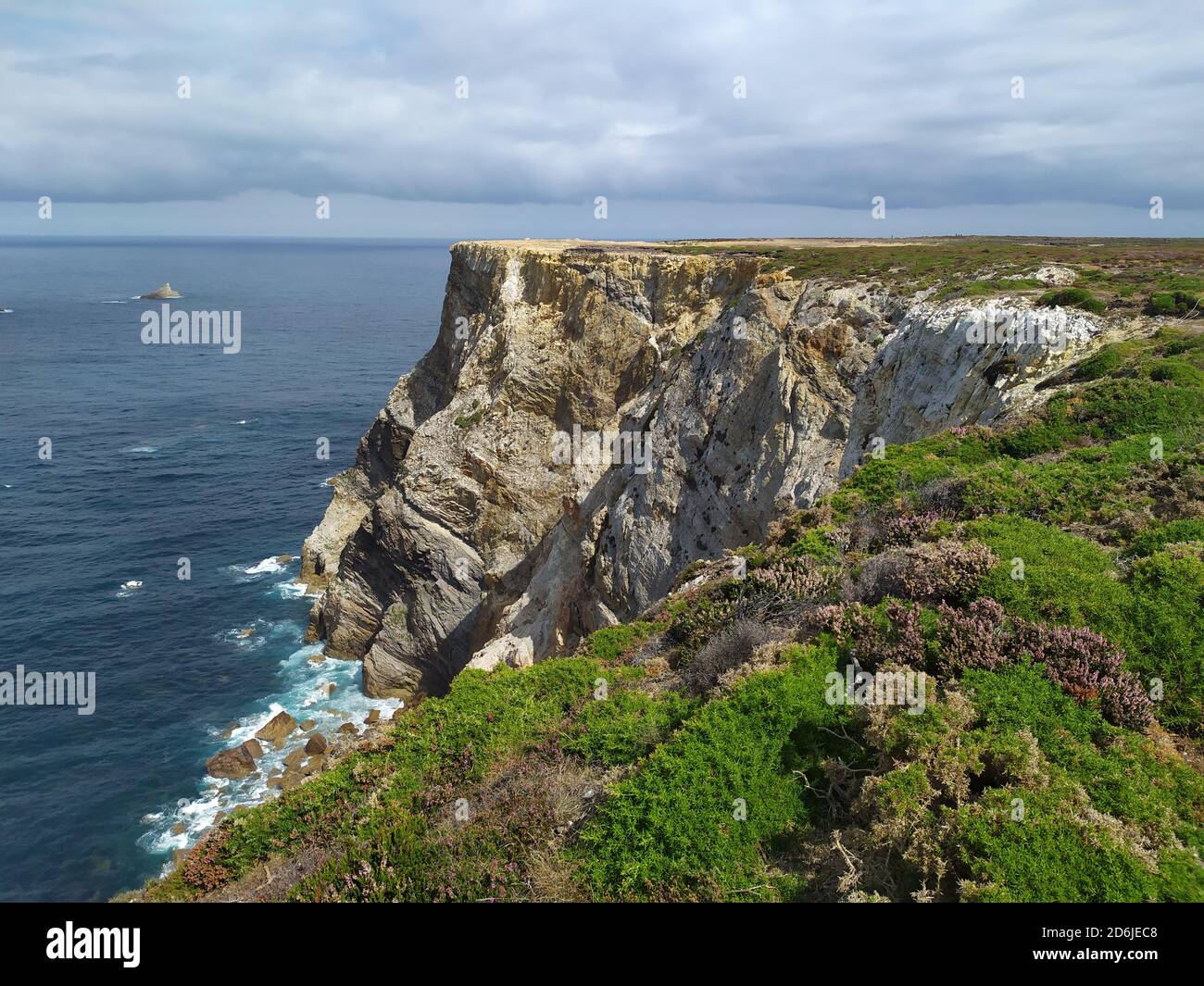 Sea surrounded by cliffs covered in the grass under a cloudy sky Stock ...