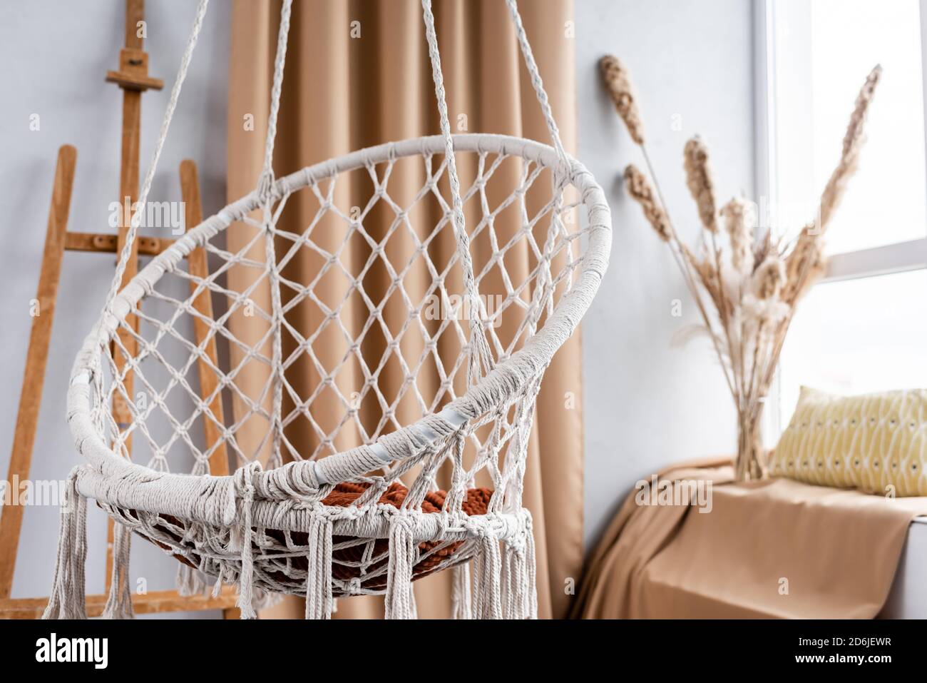 Modern studio interior with hanging chair and easel Stock Photo