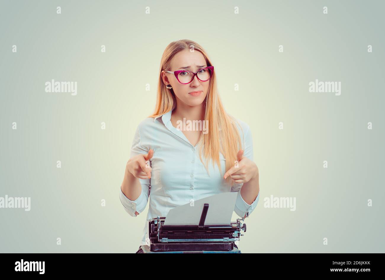 Look right here I am writing a story. Writer journalist at work. Woman young girl typing on a typewriter old writing machine pointing on paper isolate Stock Photo