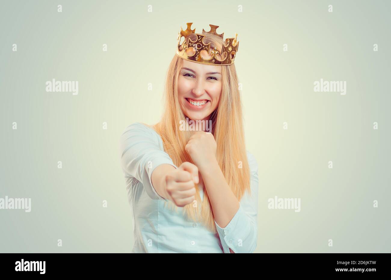 Closeup portrait of young, beautiful, excited, happy woman smiling, laughing, pointing finger towards you, camera gesture, isolated light yellow green Stock Photo