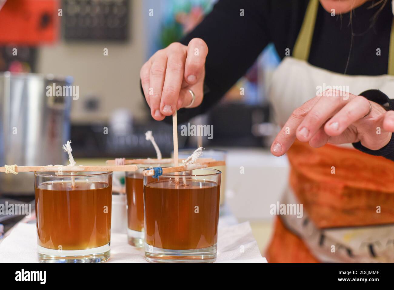 Creative occupation of candle making showing the pouring of liquid wax ...