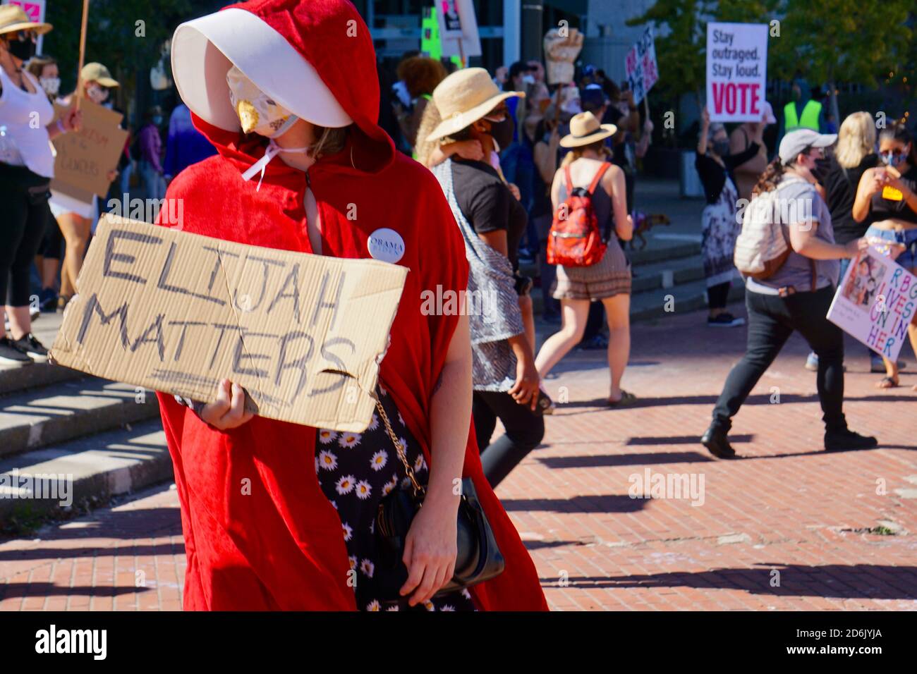 October 17, 2020. San Francisco Women's March. Pro-choice protester dressed as red handmaiden with sign that reads 'Elijah Matters'. Stock Photo
