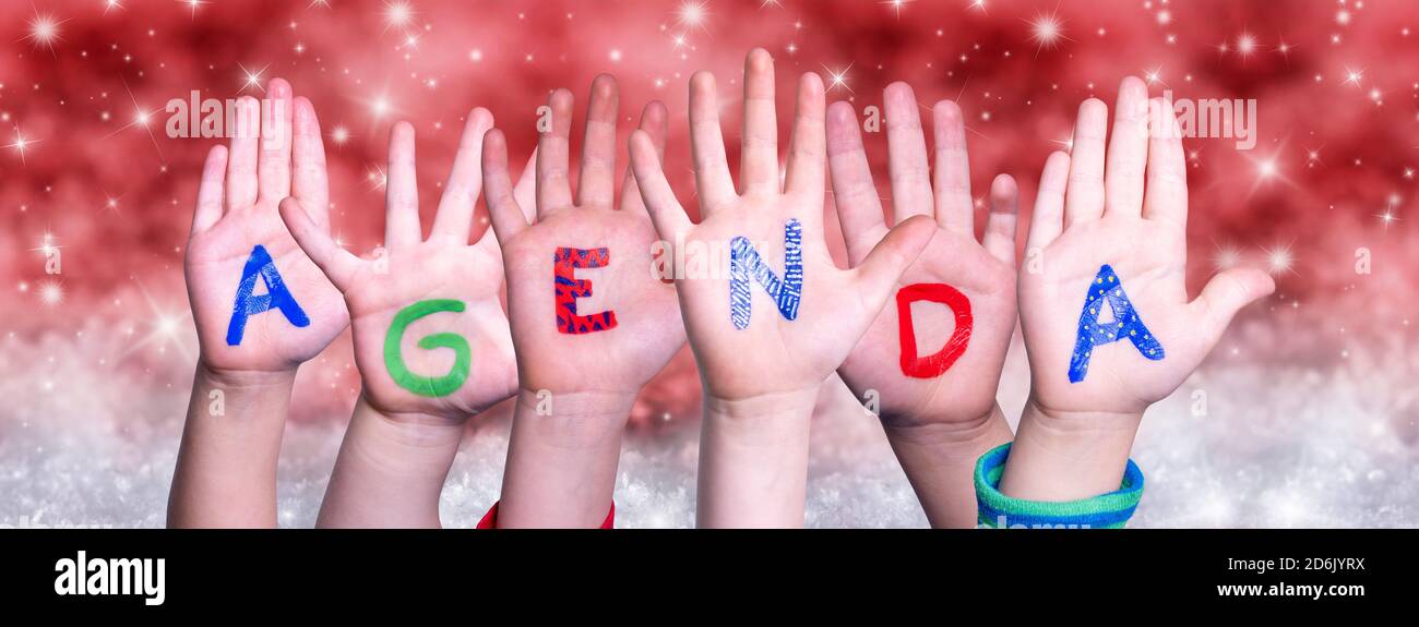Children Hands Building Word Agenda, Red Christmas Background Stock Photo
