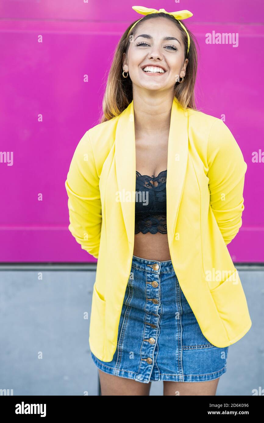 Young woman wearing a yellow jacket and headband Stock Photo - Alamy