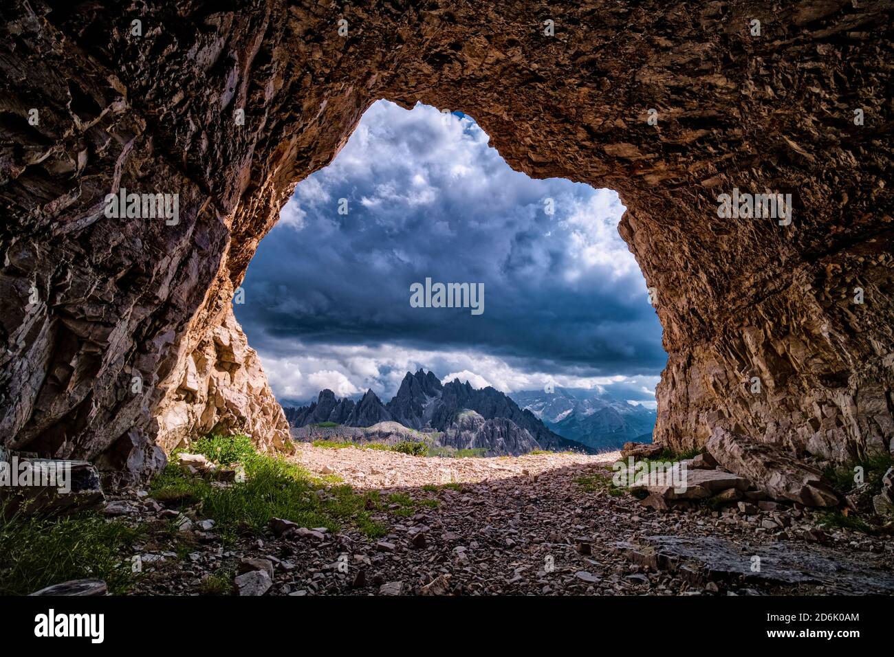 The mountain group Cadini di Misurina seen out of a cave above the mountain hut Auronzo, Rifugio Auronzo, dark thunderstorm clouds moving in. Stock Photo