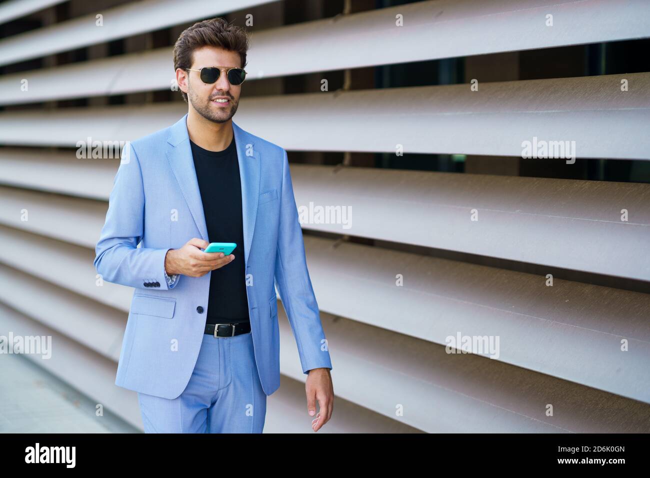 Man walking down the street using his smartphone Stock Photo