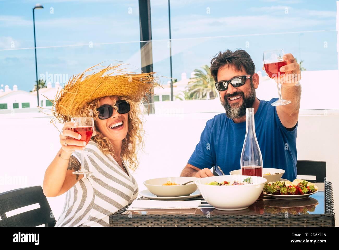 People on vacation and summer holidays activity together in couple - happy man and woman adult mature enjoy the lunch and the red wine having fun and Stock Photo