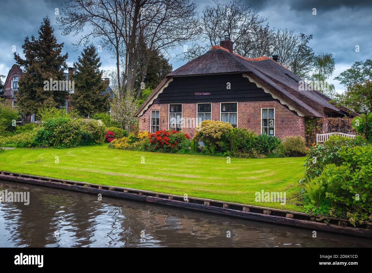 Beautiful waterfront house and ornamental garden with colorful flowers, Giethoorn, Netherlands, Europe Stock Photo
