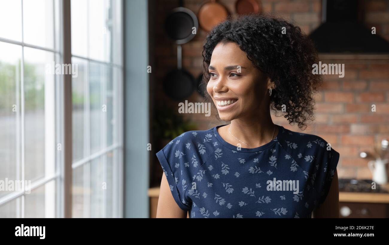 Smiling African American woman look in distance dreaming Stock Photo ...