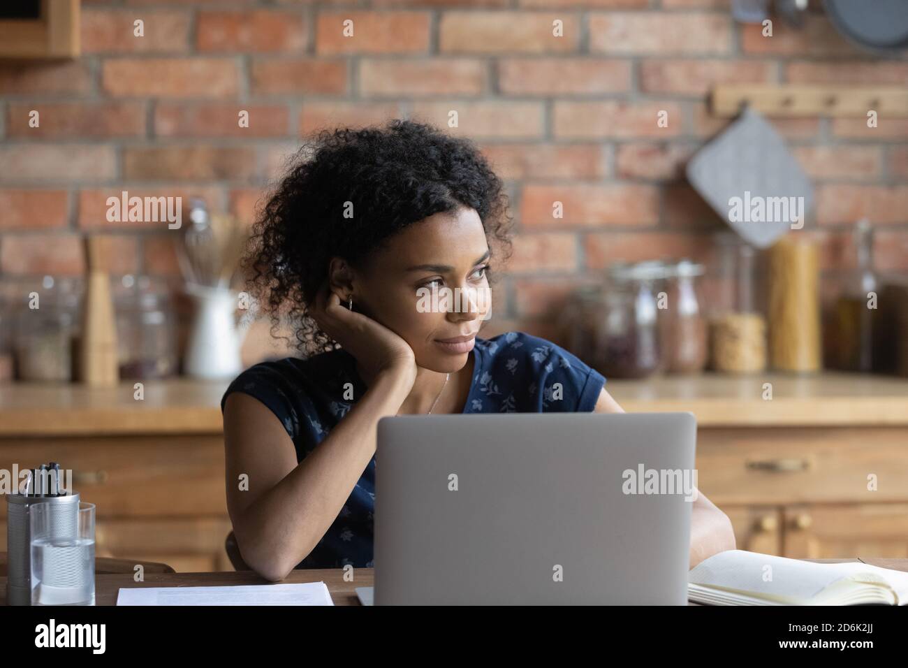 Young Africana American woman distracted from computer dreaming Stock Photo